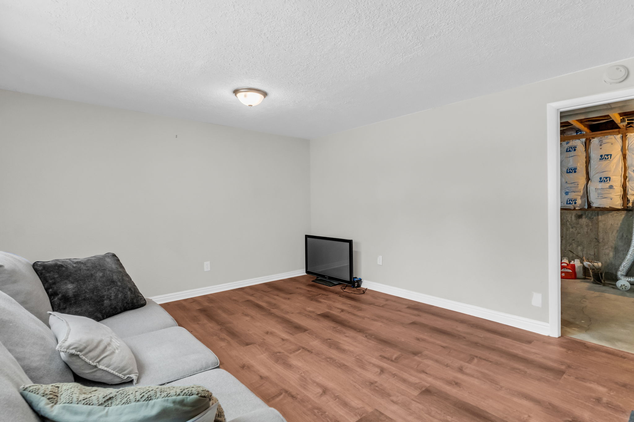 Neutral-toned room featuring wood-finish flooring and white trim