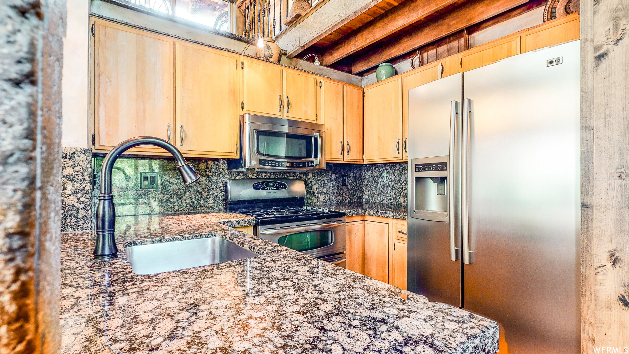 Kitchen featuring granite countertops, wood cabinetry, stainless steel appliances, and a built-in range with a microwave
