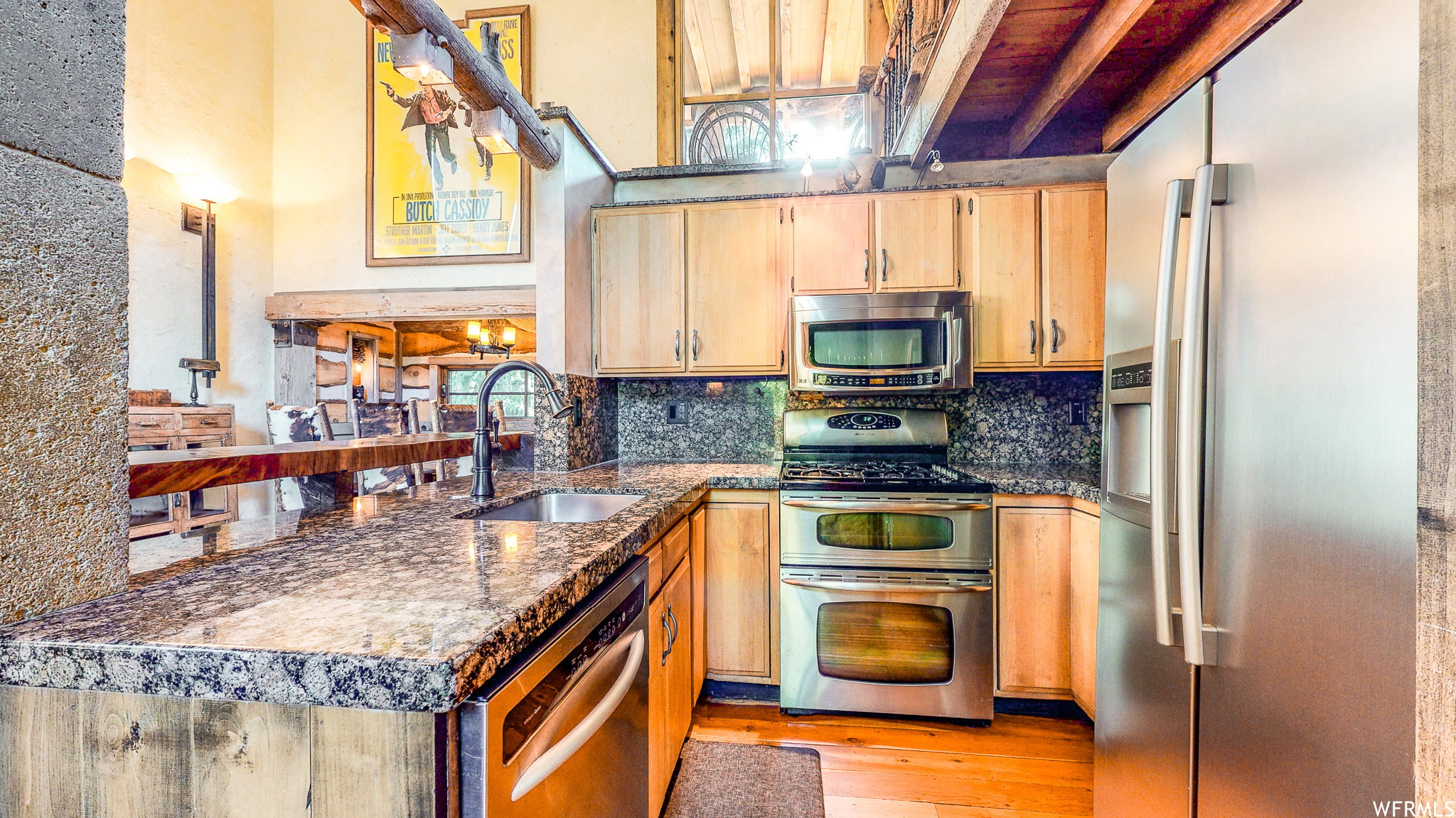 Kitchen featuring stone-finish countertops, stainless steel appliances, light wood cabinetry, a built-in microwave, and a double oven