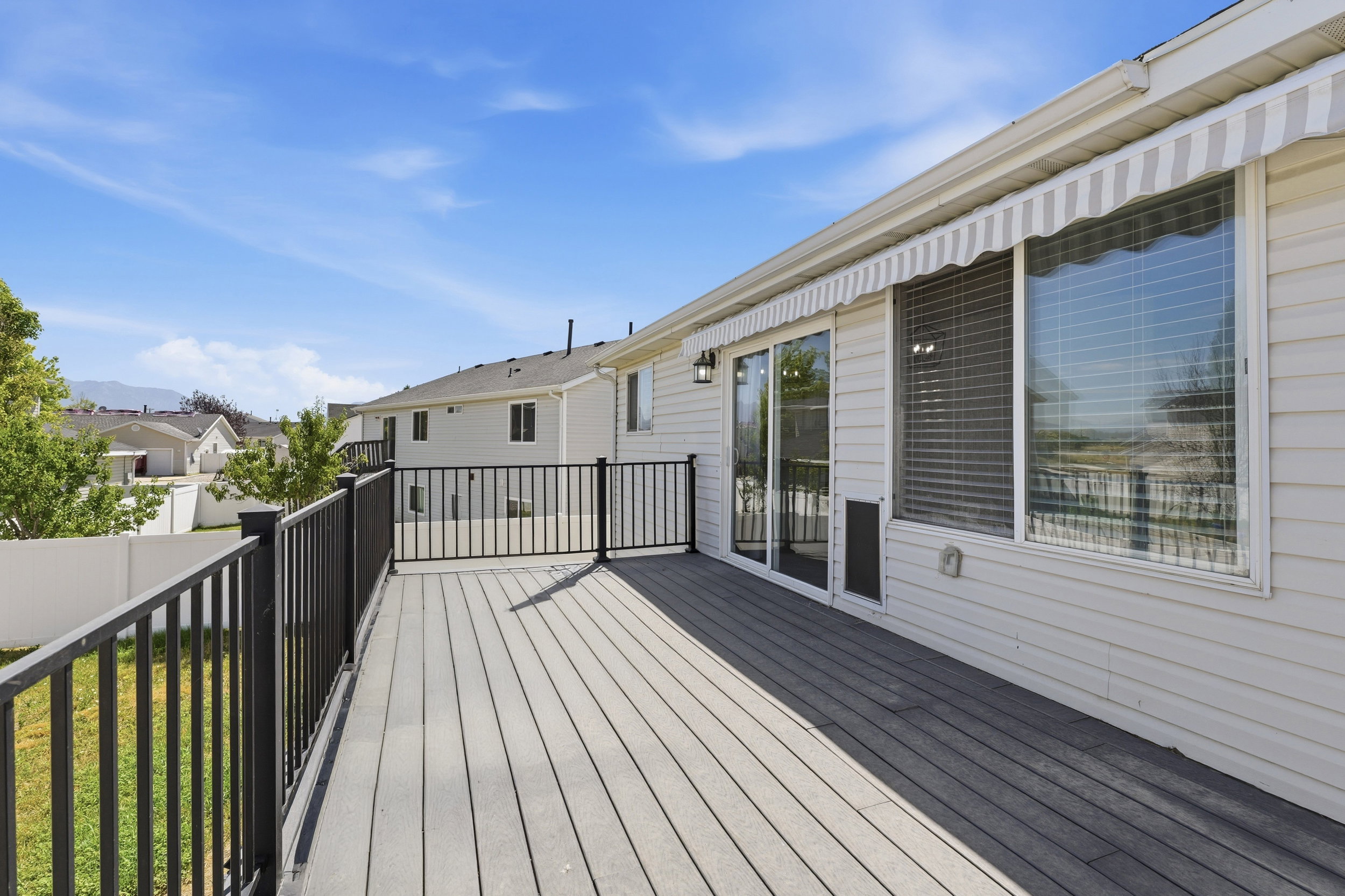 Spacious outdoor deck with composite decking and black metal railings