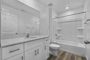 Contemporary bathroom featuring a white vanity with integrated sink, a full-width mirror, and a white tub/shower combination