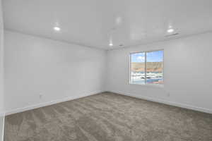 Carpeted room with recessed lighting and a large window