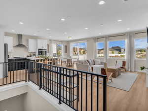 Open-concept living area featuring wood-finish flooring, recessed lighting, and expansive windows