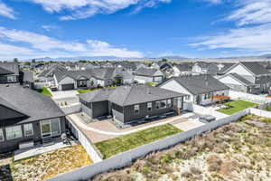 Modern single-story residence featuring a dark gray exterior and a contrasting white privacy fence