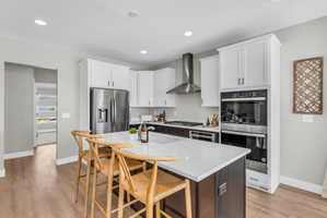 Kitchen featuring white upper cabinetry, dark lower cabinetry, and stainless steel appliances