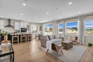 Open-concept living area featuring wood-finish flooring, recessed lighting, and expansive windows