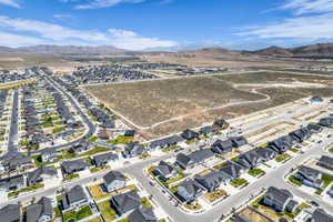 Aerial perspective of a developing residential community featuring numerous single-family homes with dark roofs and light-colored exteriors
