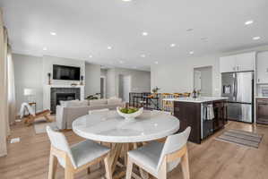 Open-concept living space featuring wood-finish flooring, recessed lighting, and a kitchen island with a built-in sink