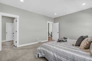 Carpeted room with light gray walls, white trim, and recessed lighting
