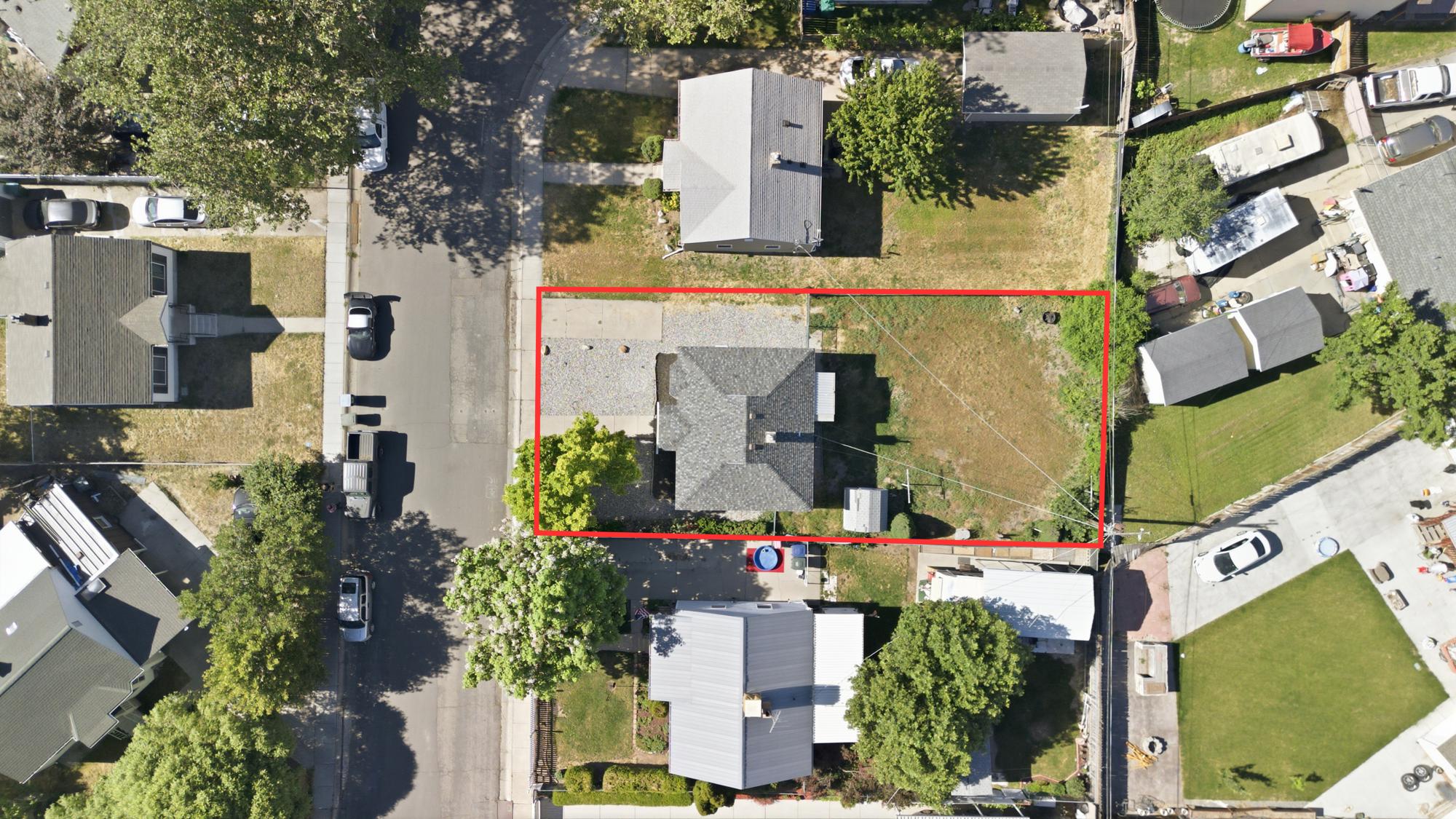 Overhead aerial view showing the full lot layout, property boundaries, yard space, and surrounding neighborhood.