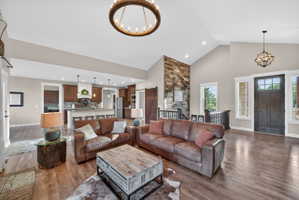 Open-concept living area featuring high vaulted ceilings and wood-finish flooring