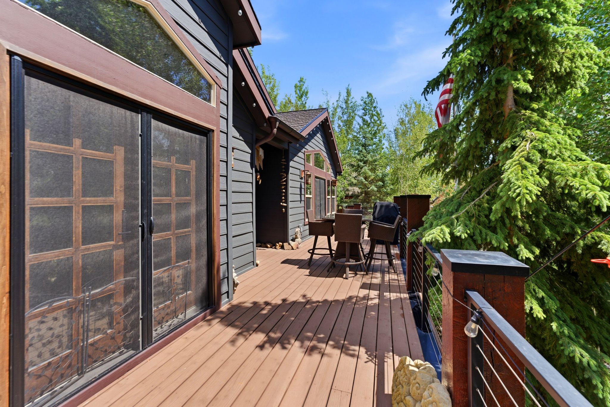 Spacious wood-finish deck with cable railing system and dark brown posts