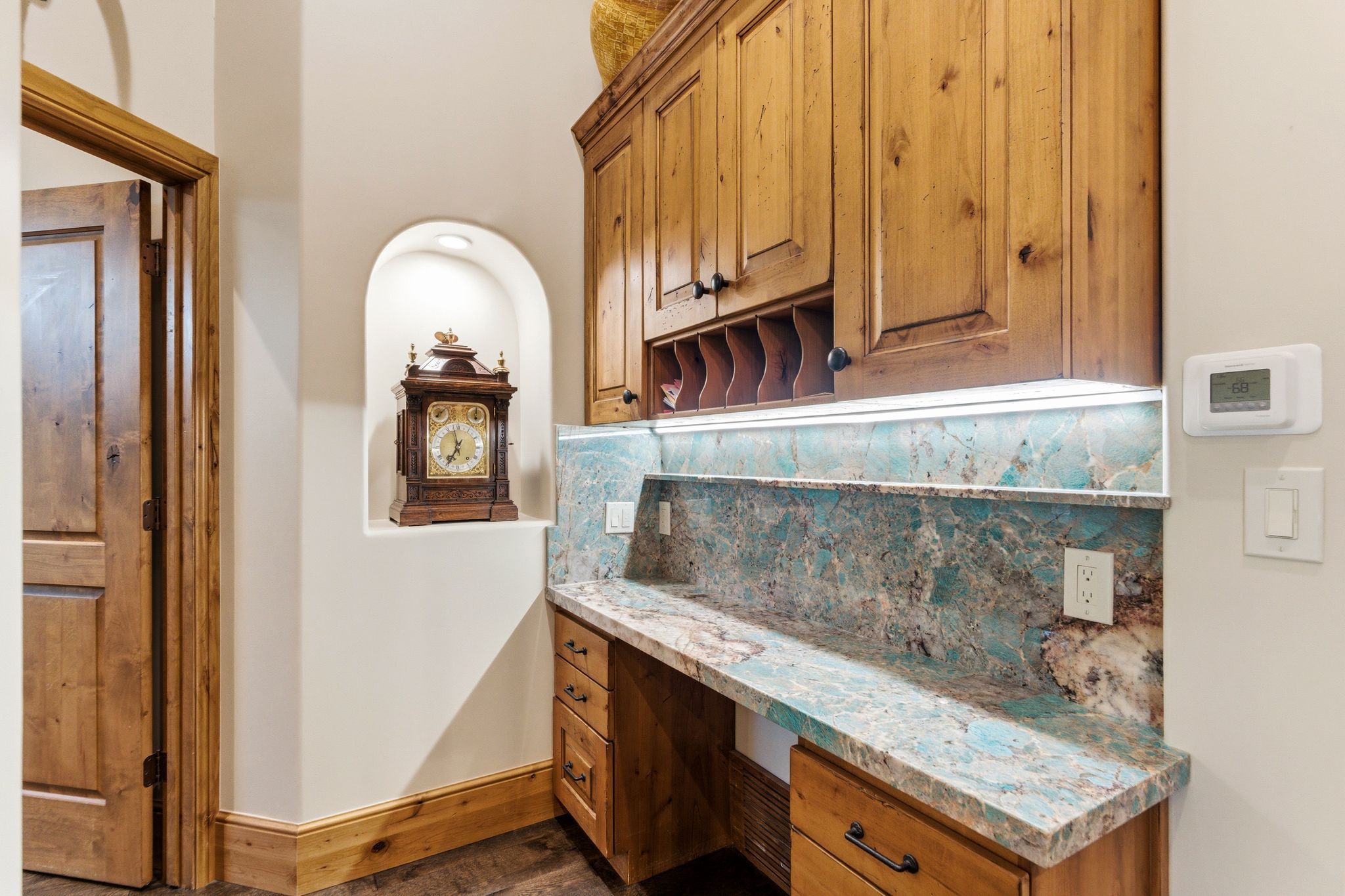 Built-in desk featuring a vibrant natural stone countertop and backsplash