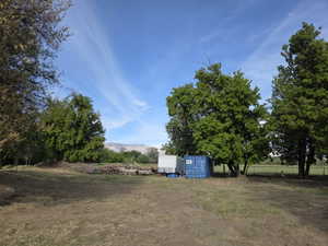 Expansive grounds featuring mature trees and a distant mountain range