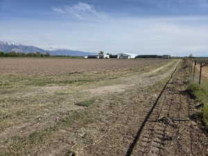 Expansive agricultural land featuring a tilled field and a distant mountain range