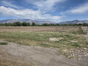 Expansive undeveloped land featuring a partial perimeter fence and distant mountains