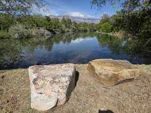 Natural water feature with surrounding greenery and distant mountains