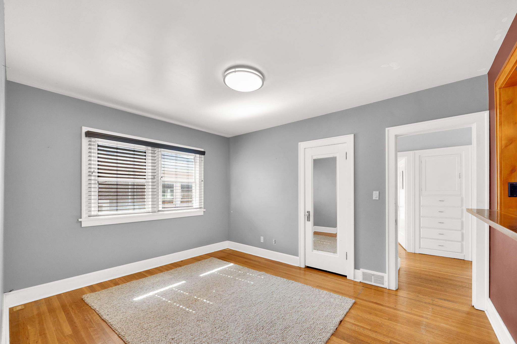 Hardwood flooring extends throughout this room, featuring a white trim baseboard