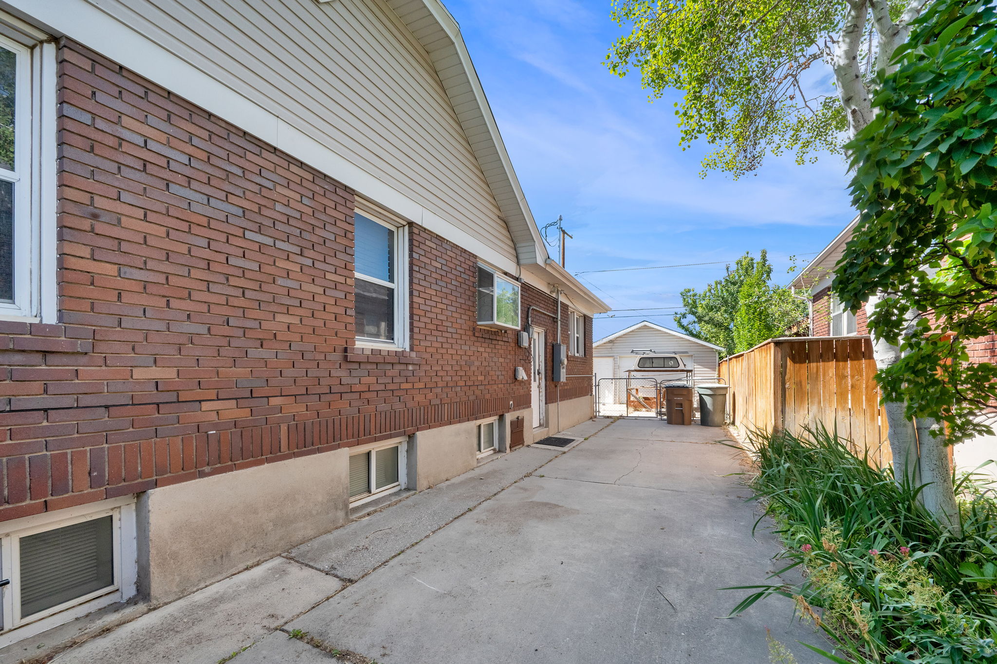 Long concrete driveway leading to a detached garage