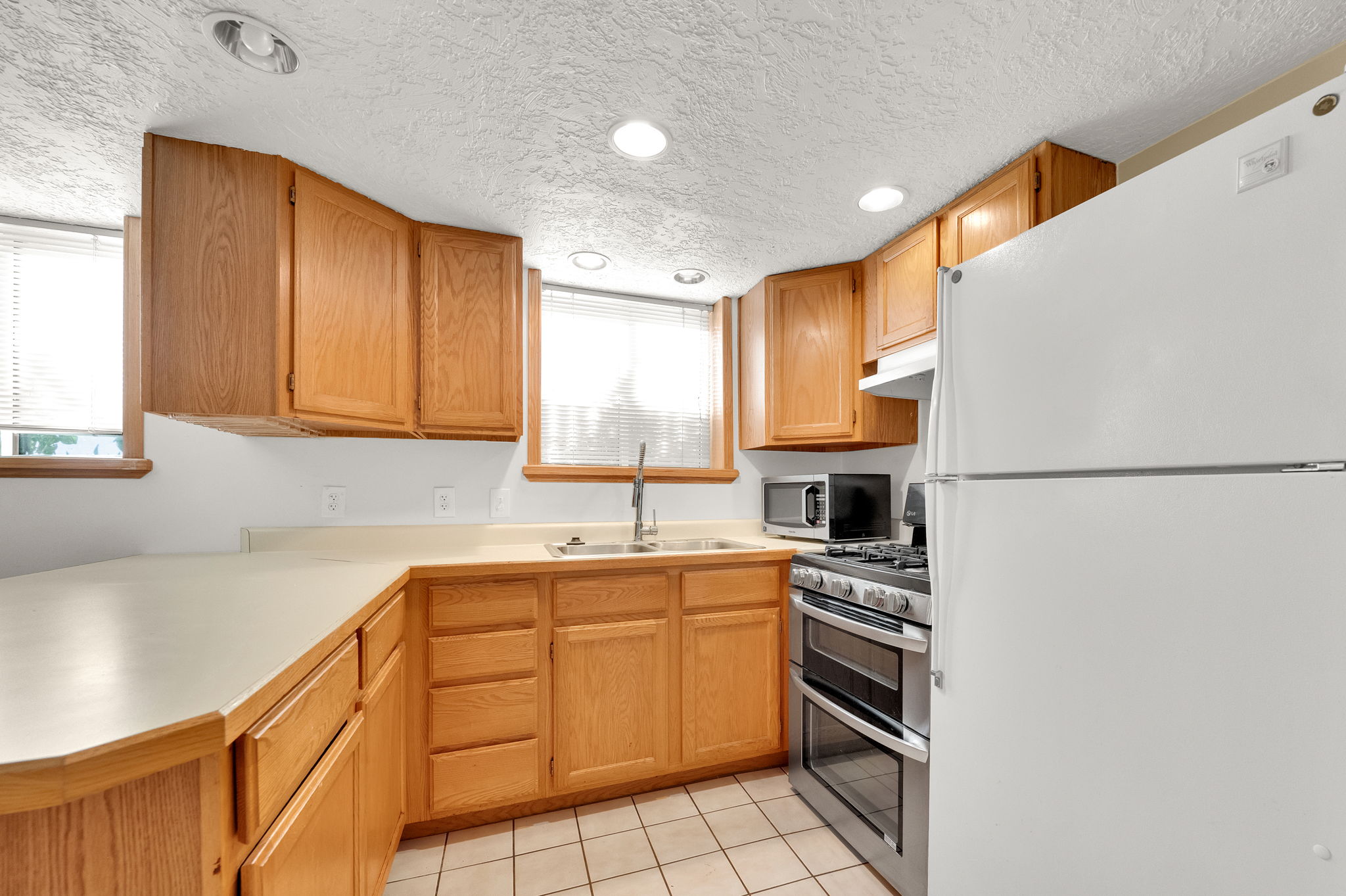 Kitchen featuring wood cabinetry, light countertops, and tile flooring