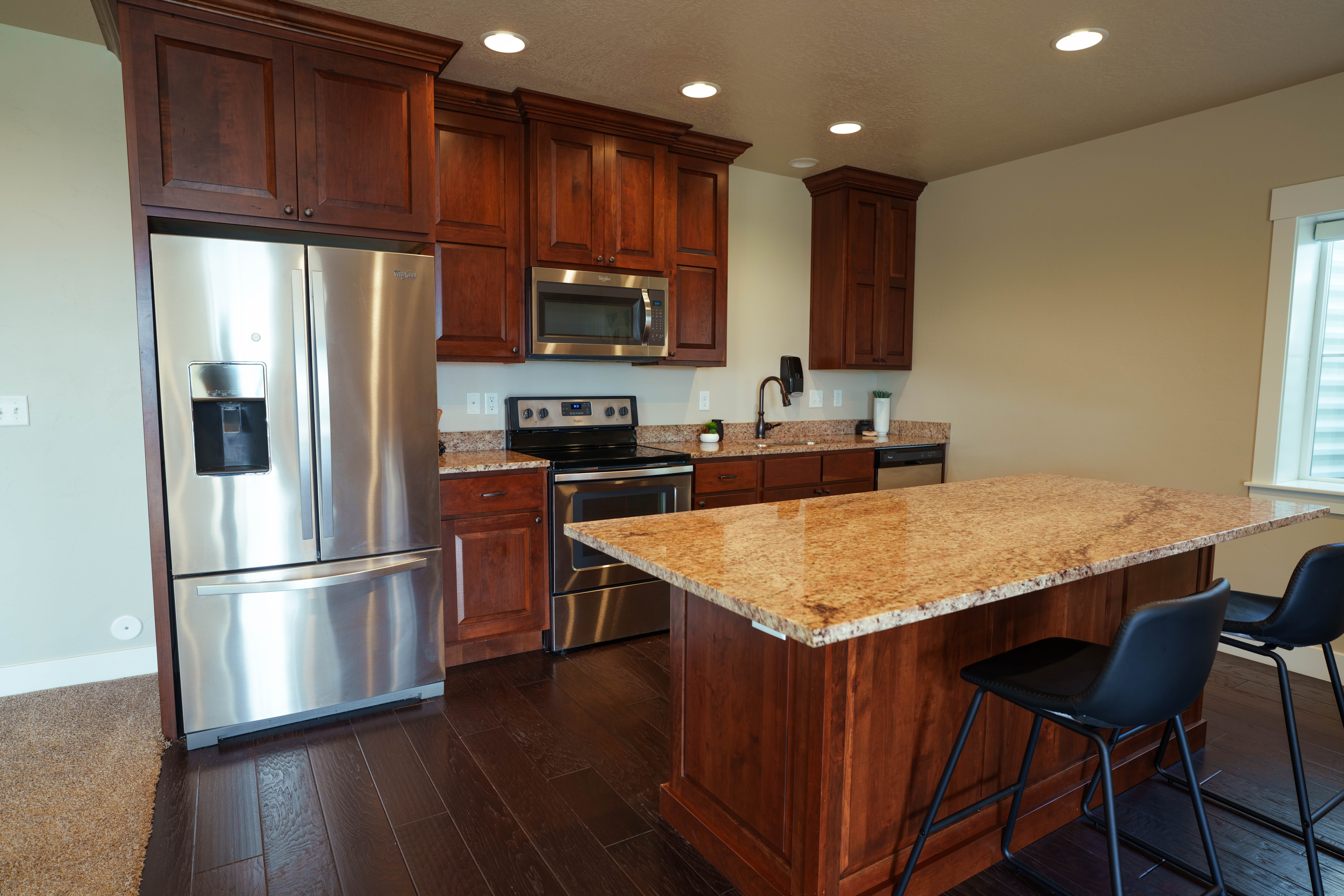 Kitchen featuring dark wood-finish flooring, recessed lighting, and a window with blinds