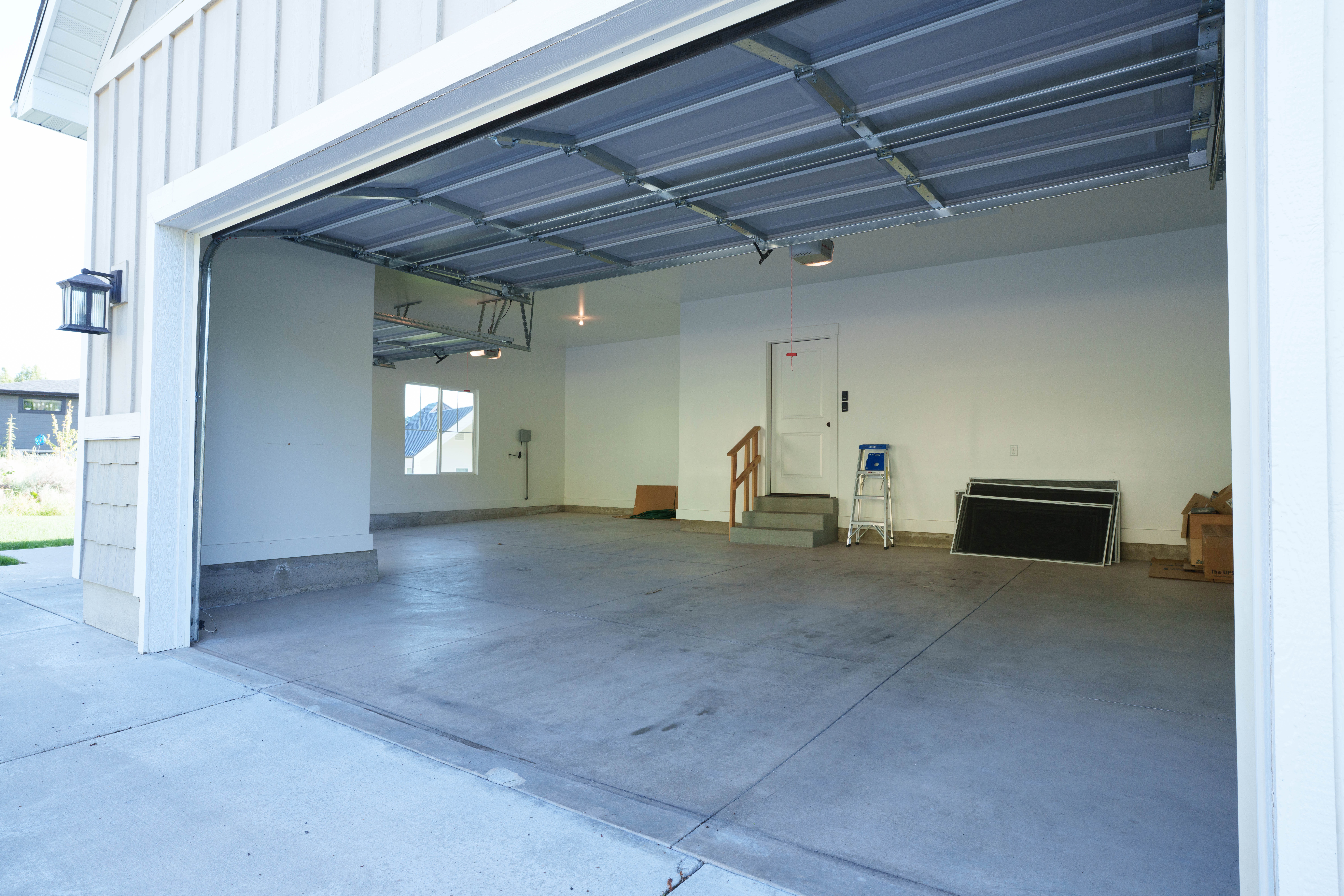 Spacious three-car garage with a concrete floor and white painted walls