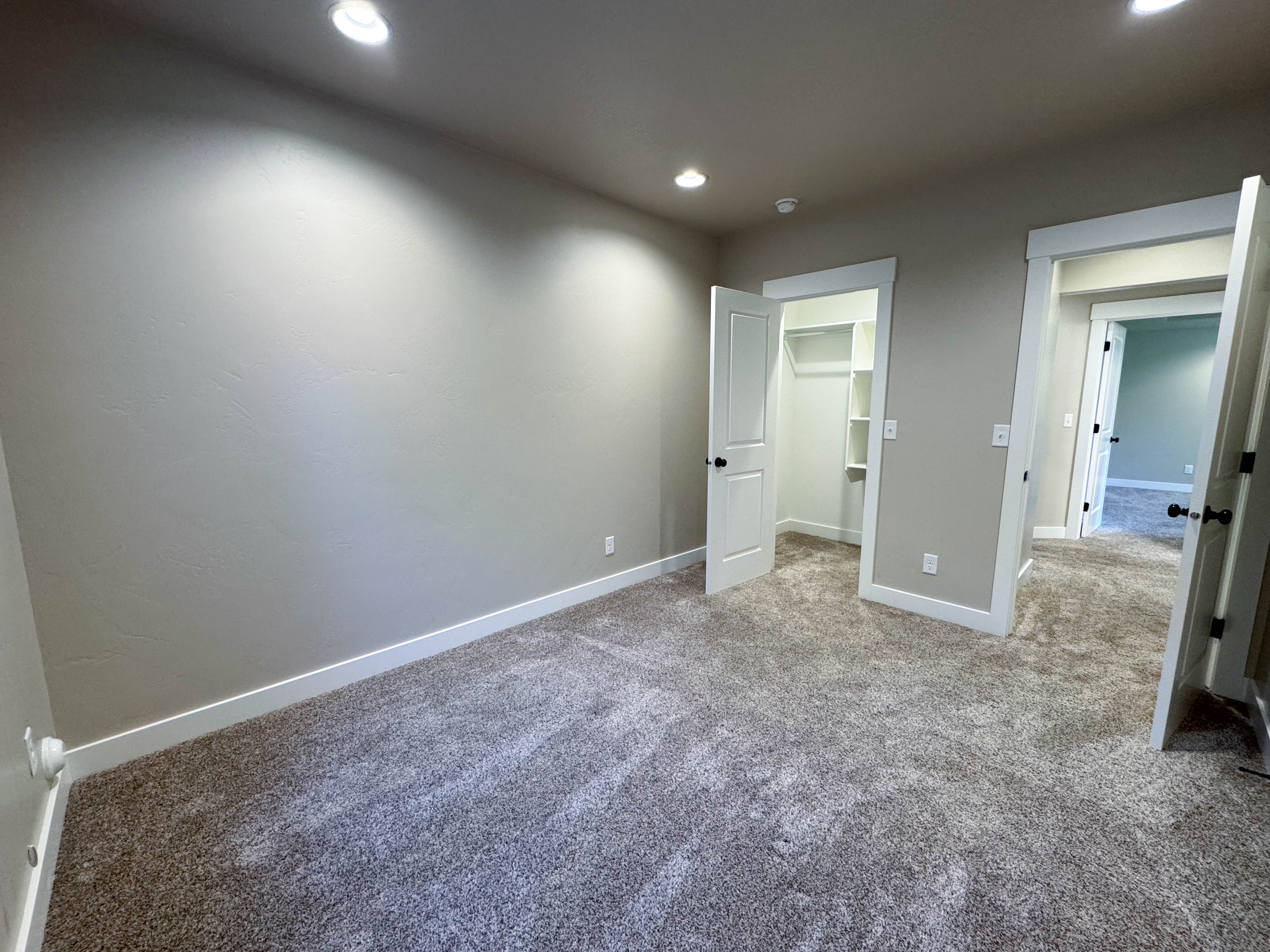Neutral-toned room featuring plush carpeting, recessed lighting, and white trim