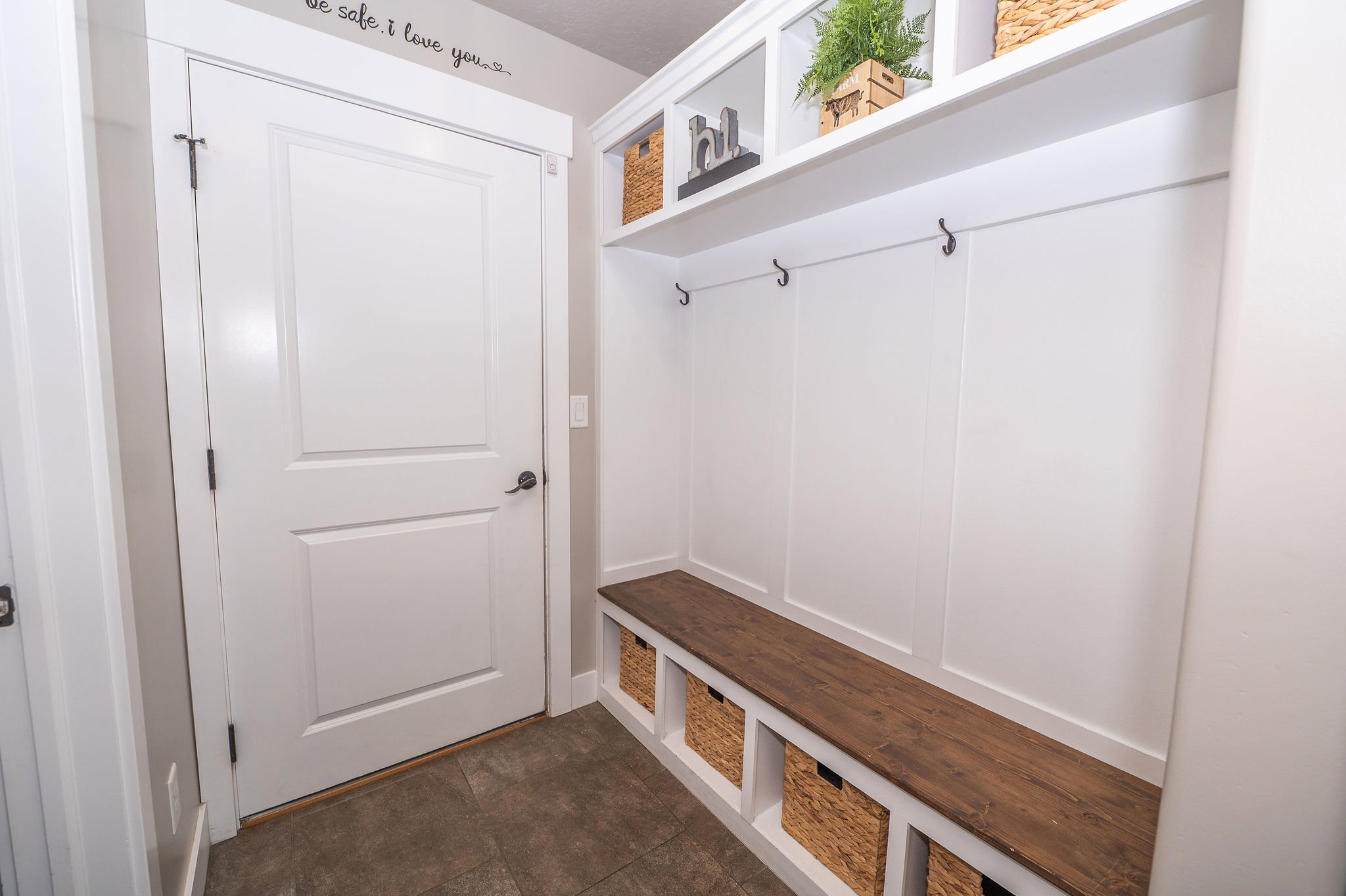 Built-in mudroom bench with rich wood-finish top and integrated storage cubbies