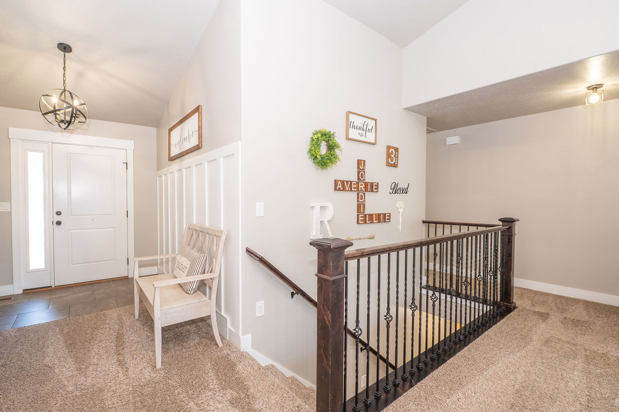 Entryway featuring a white paneled door with sidelight, tile flooring, and a contemporary spherical chandelier
