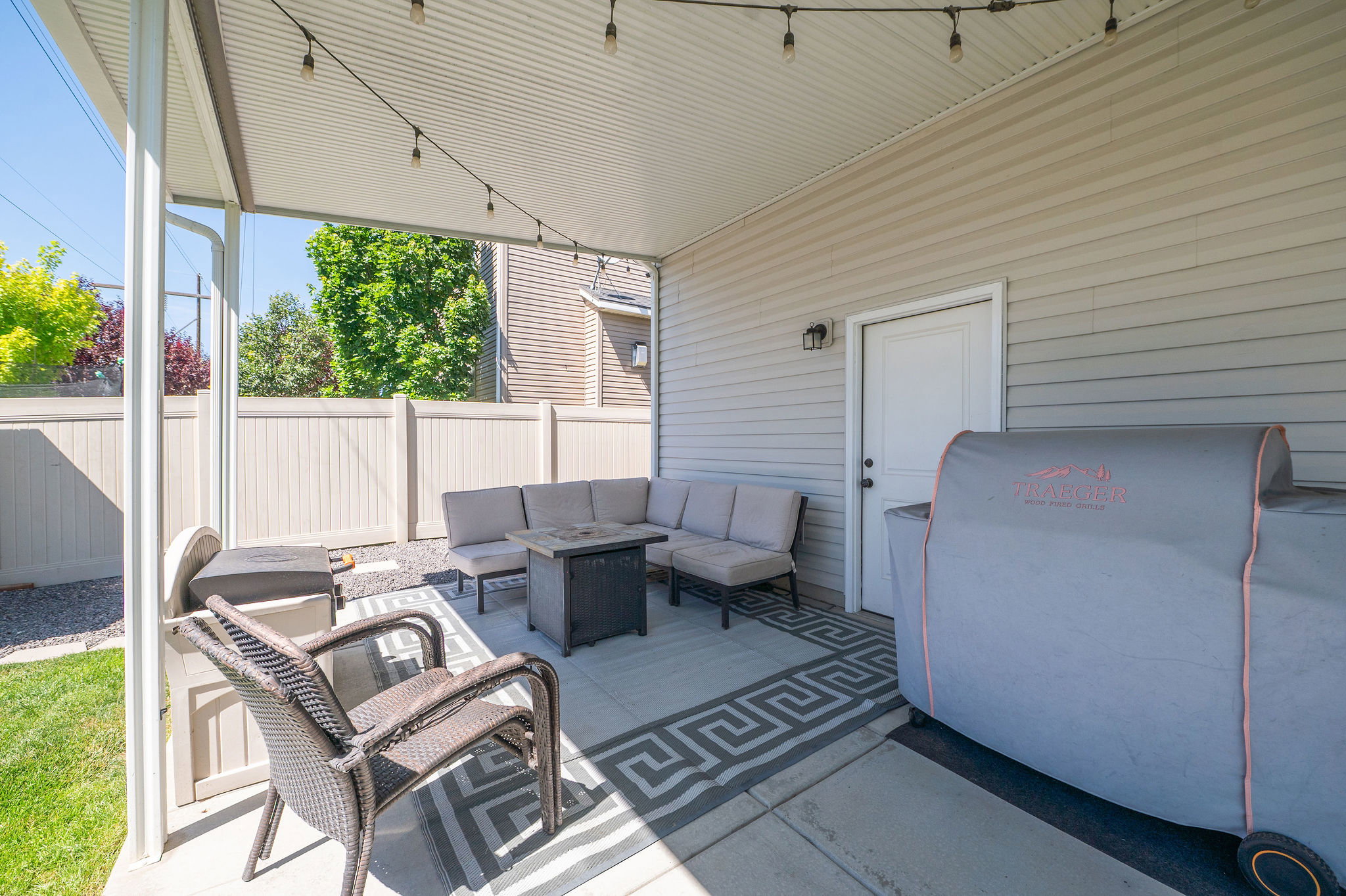 Expansive covered patio featuring string lighting and direct exterior access