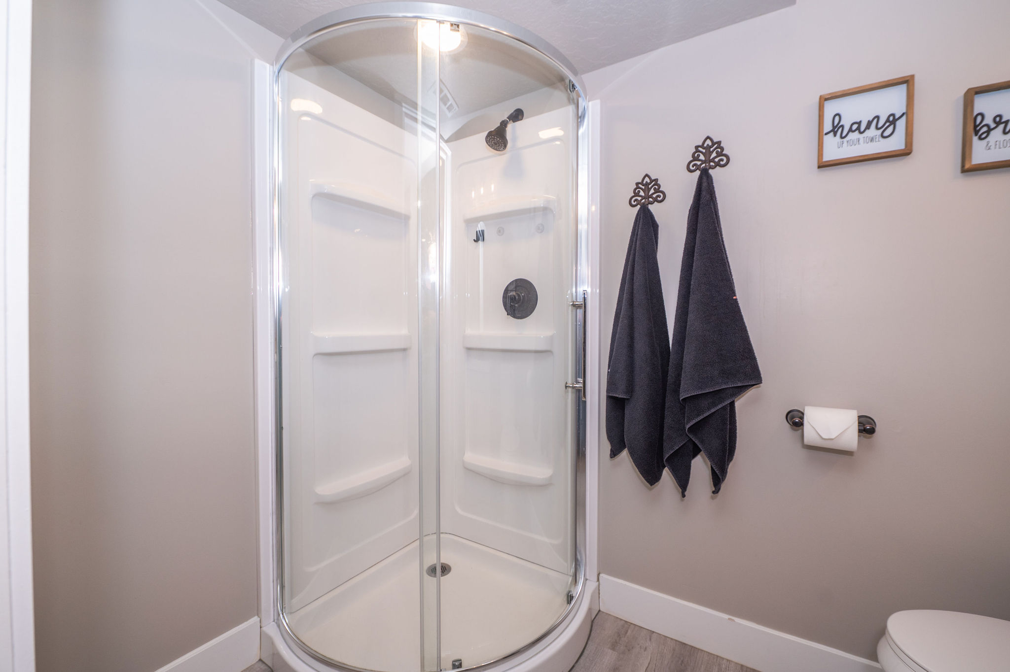 Corner shower enclosure with clear glass doors and a white shower base