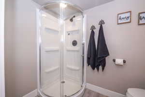 Corner shower enclosure with clear glass doors and a white shower base