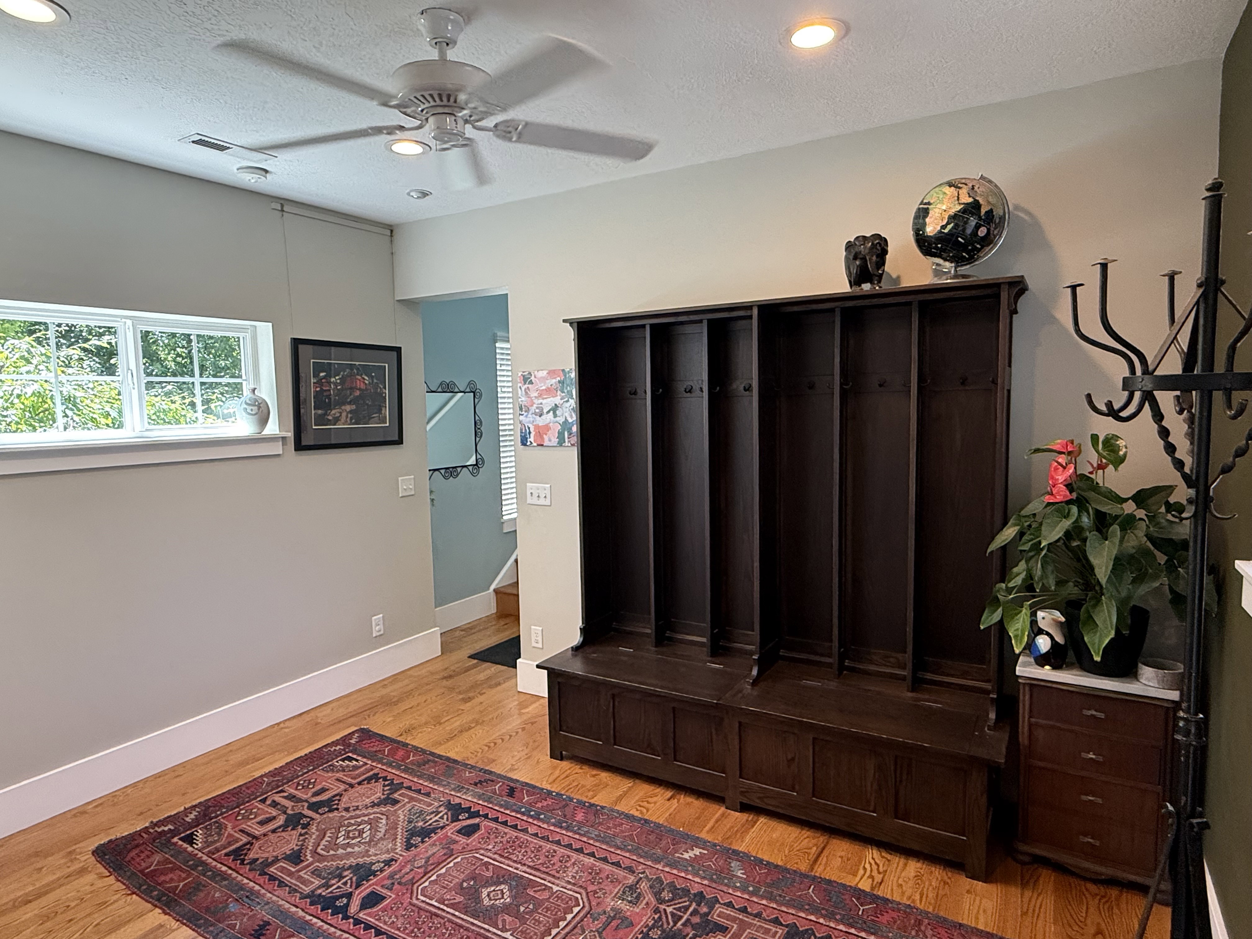 Hardwood flooring, recessed lighting, and a ceiling fan create a bright and airy entry