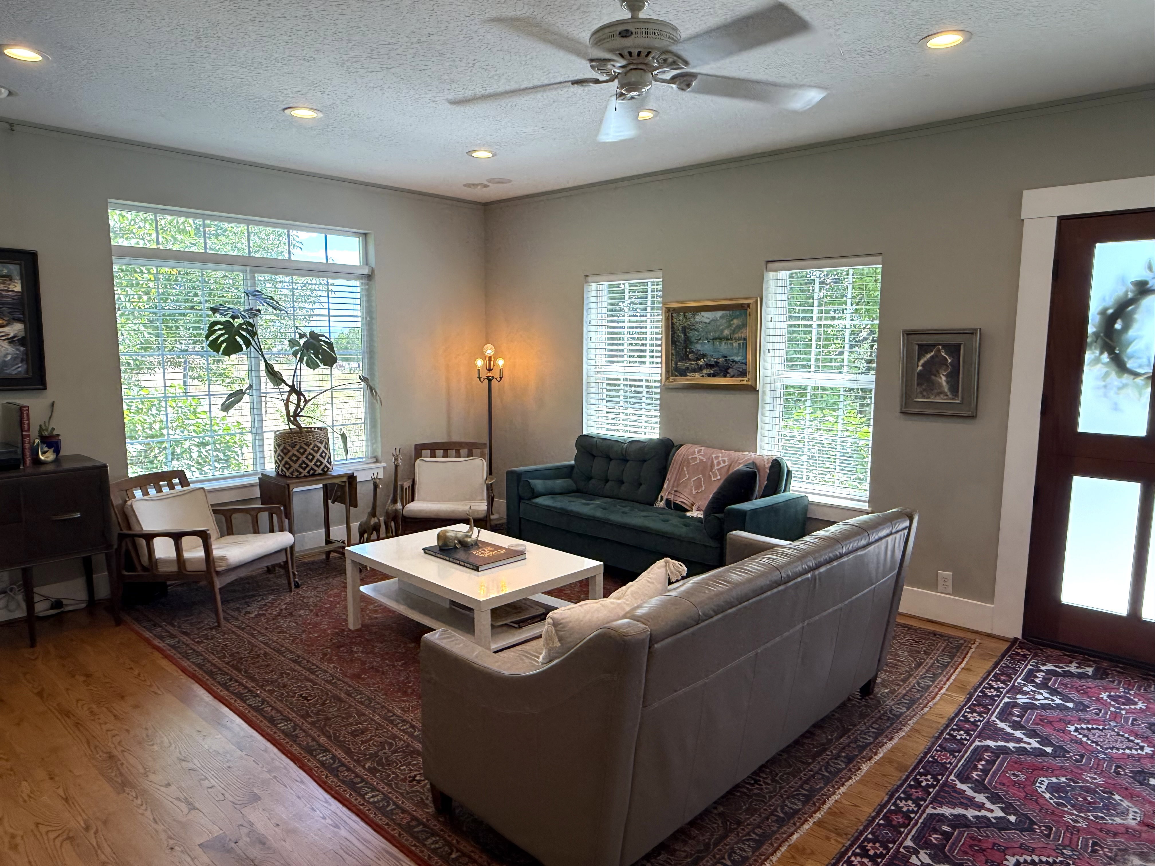 Spacious living area featuring wood-finish flooring, recessed lighting, and a ceiling fan