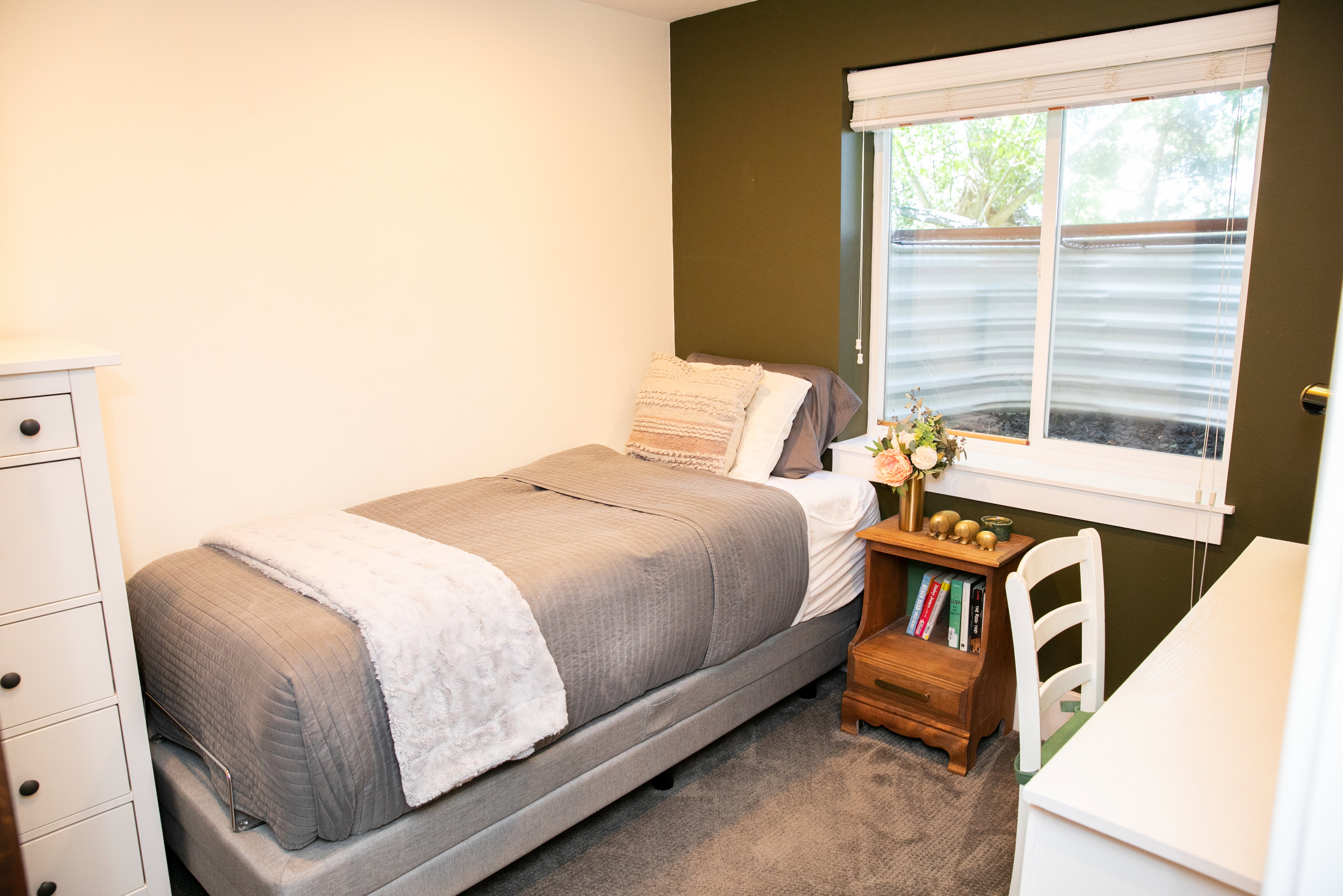 Carpeted room with a window featuring horizontal blinds