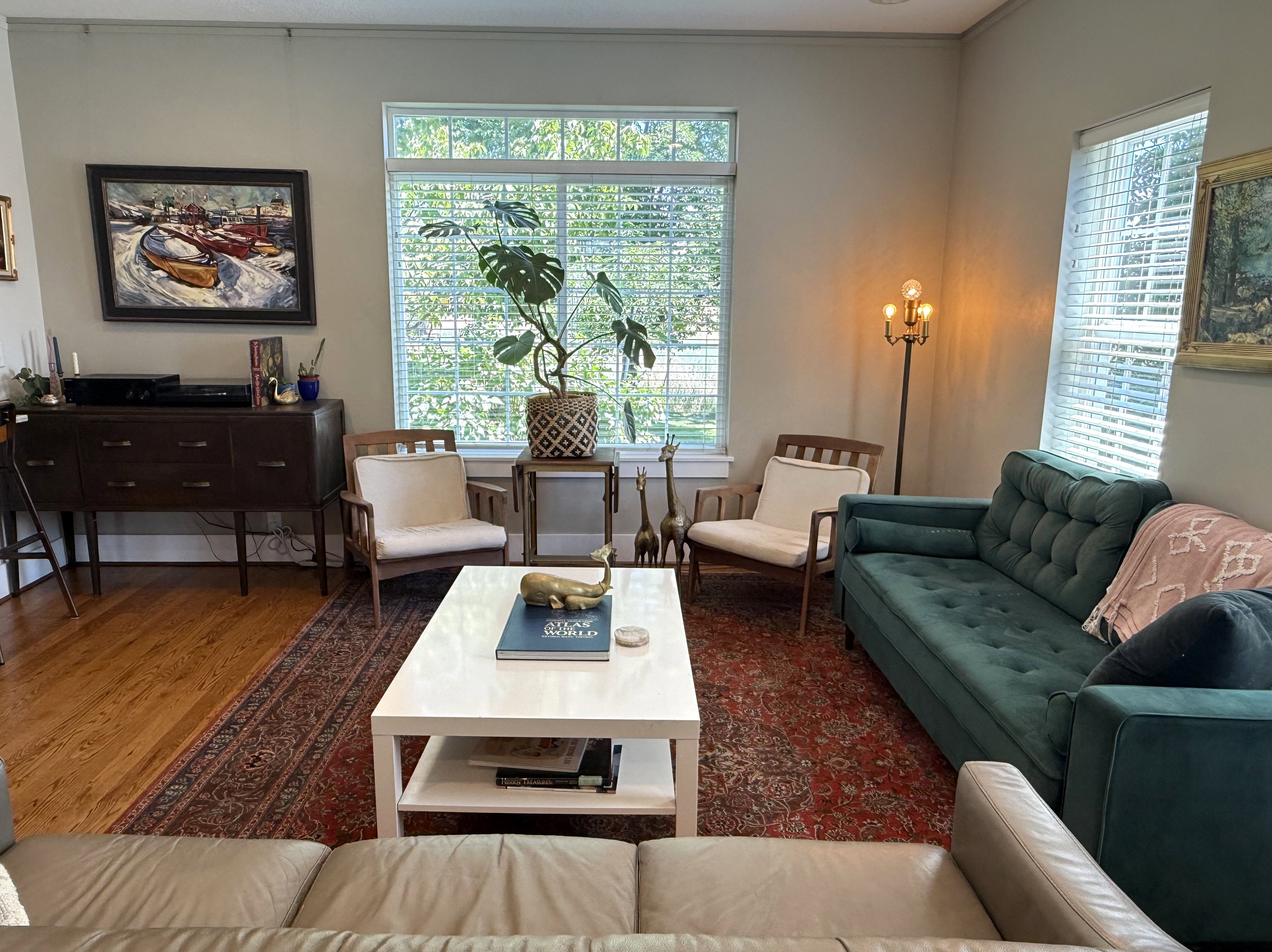 Hardwood flooring throughout featuring multiple windows with blinds, a built-in wall niche, and crown molding