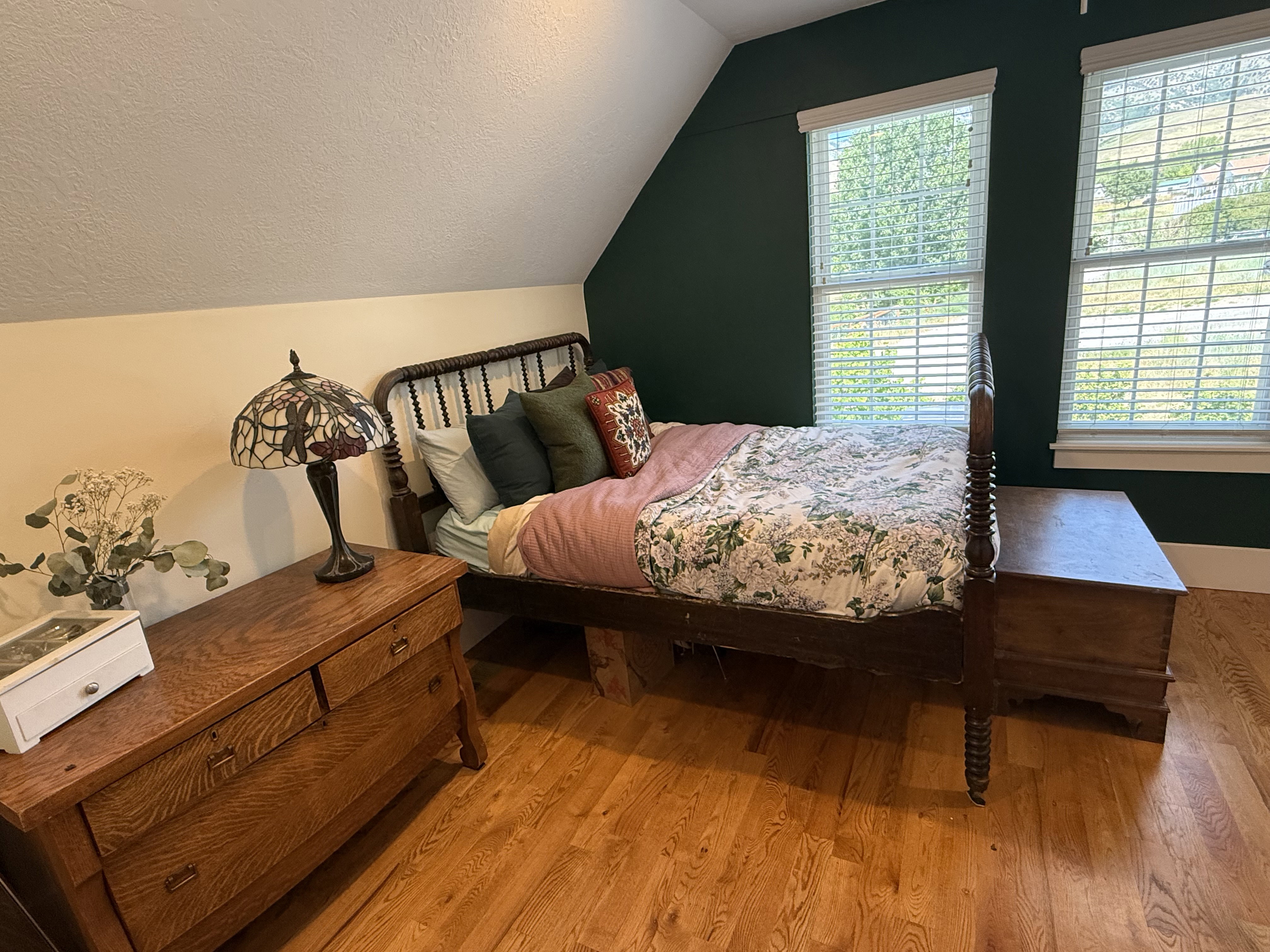Hardwood flooring complements a room with sloped ceilings and accent wall