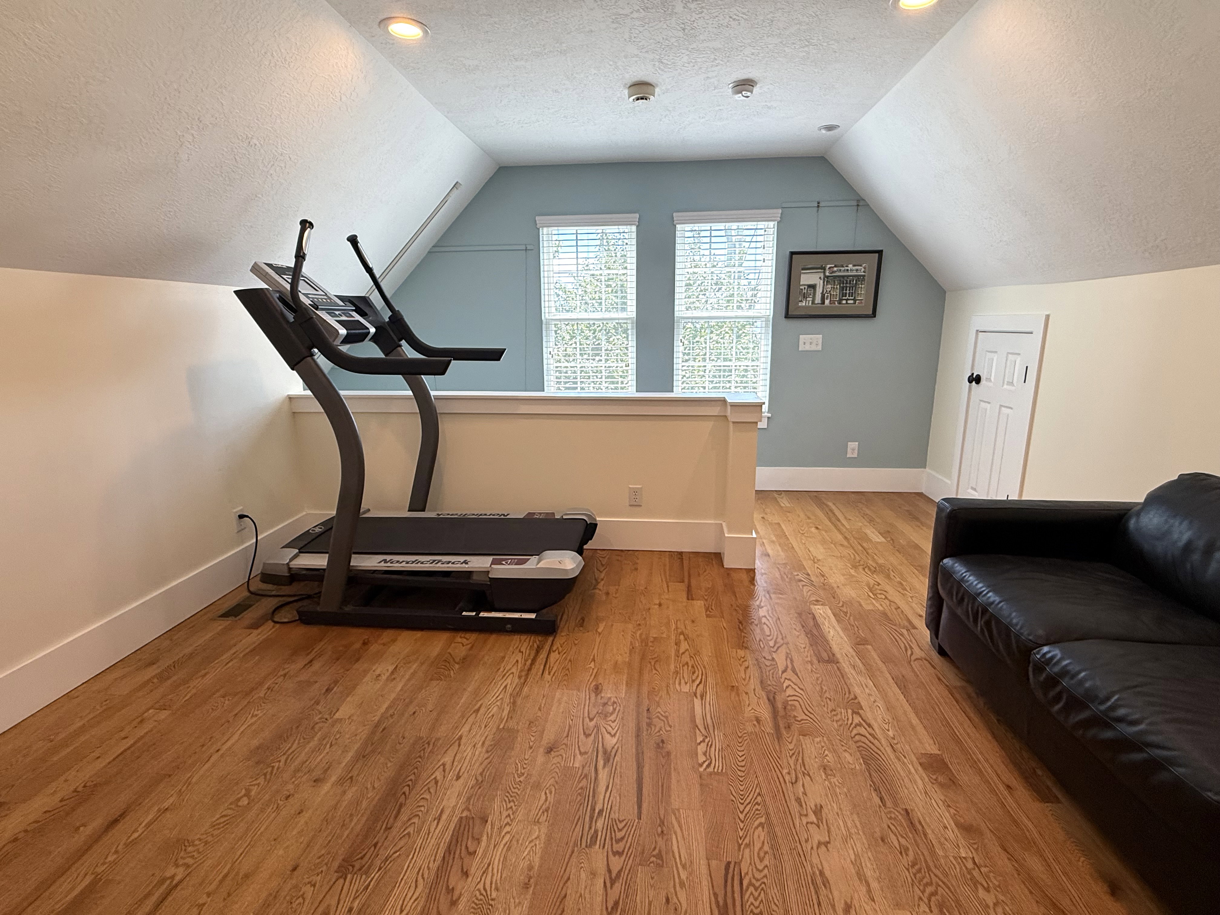 Attic space featuring wood-finish flooring, recessed lighting, and sloped ceilings