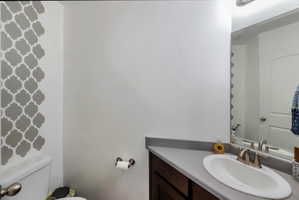 Bathroom vanity with a white oval sink, brushed nickel faucet, and a gray countertop