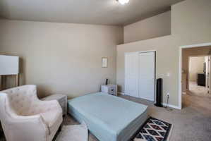 Carpeted room featuring a vaulted ceiling and neutral wall tones