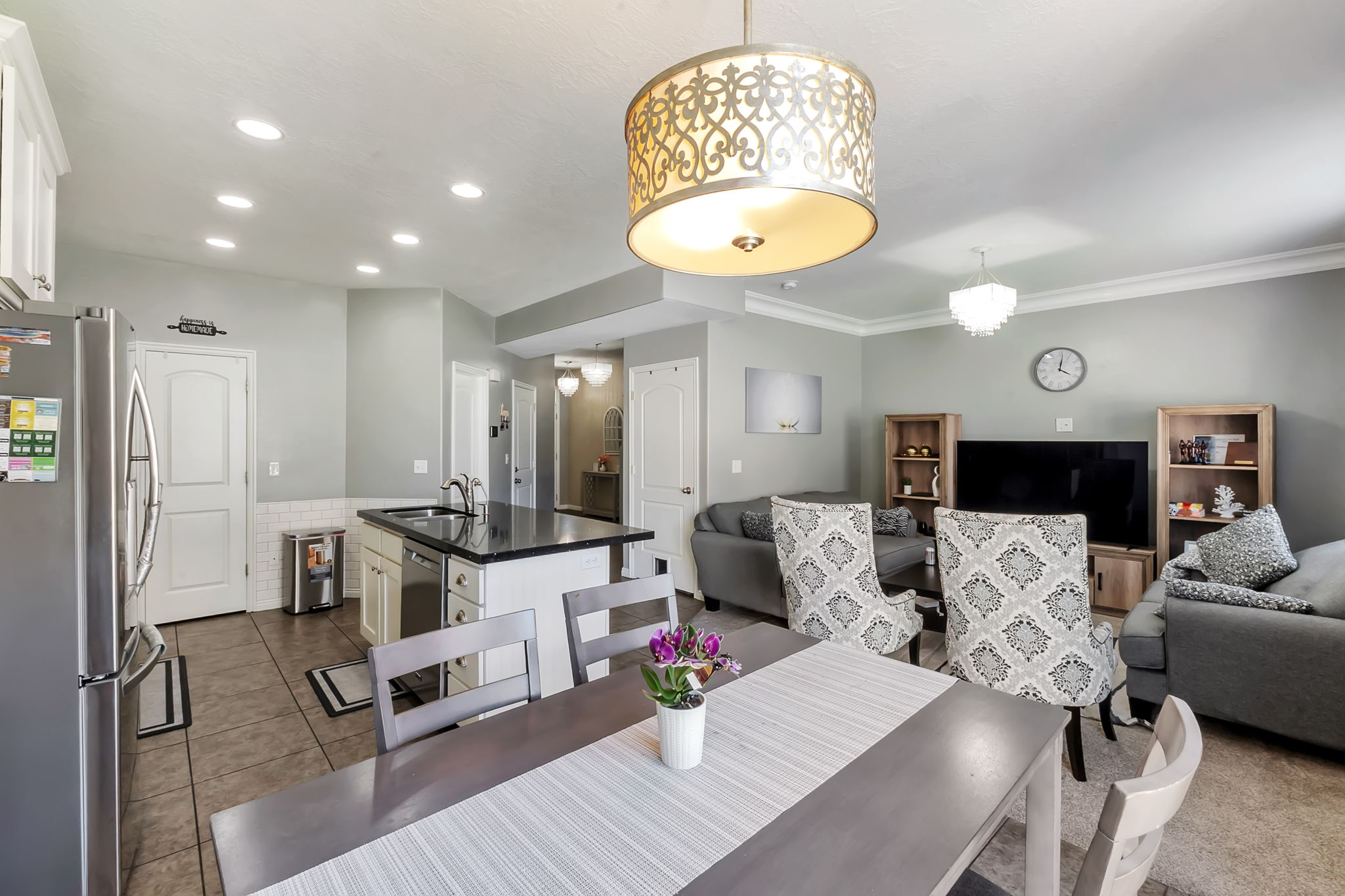 Open-concept common area featuring a kitchen island with dark stone countertop, recessed lighting, and crown molding