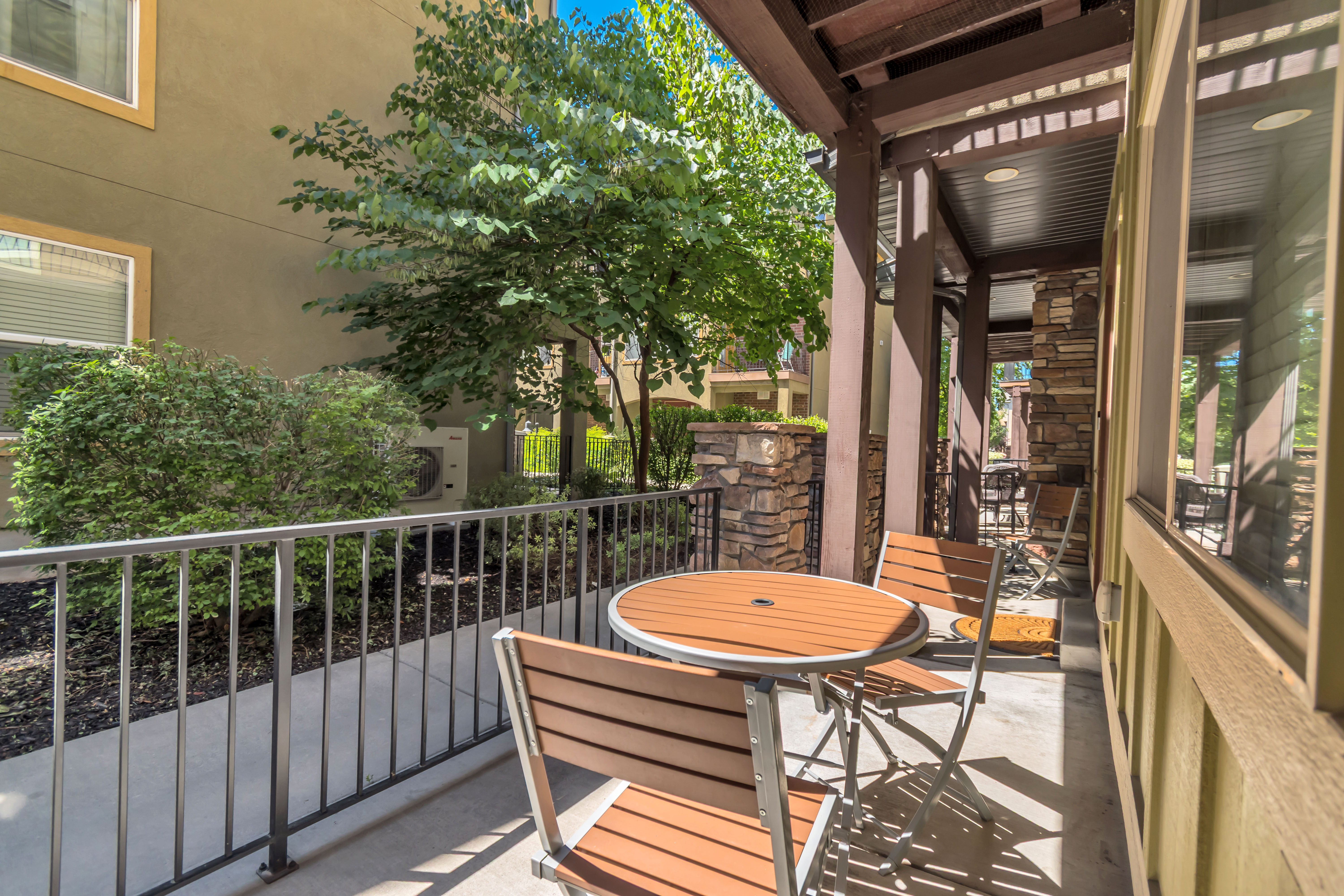 Covered patio with a metal railing and concrete flooring