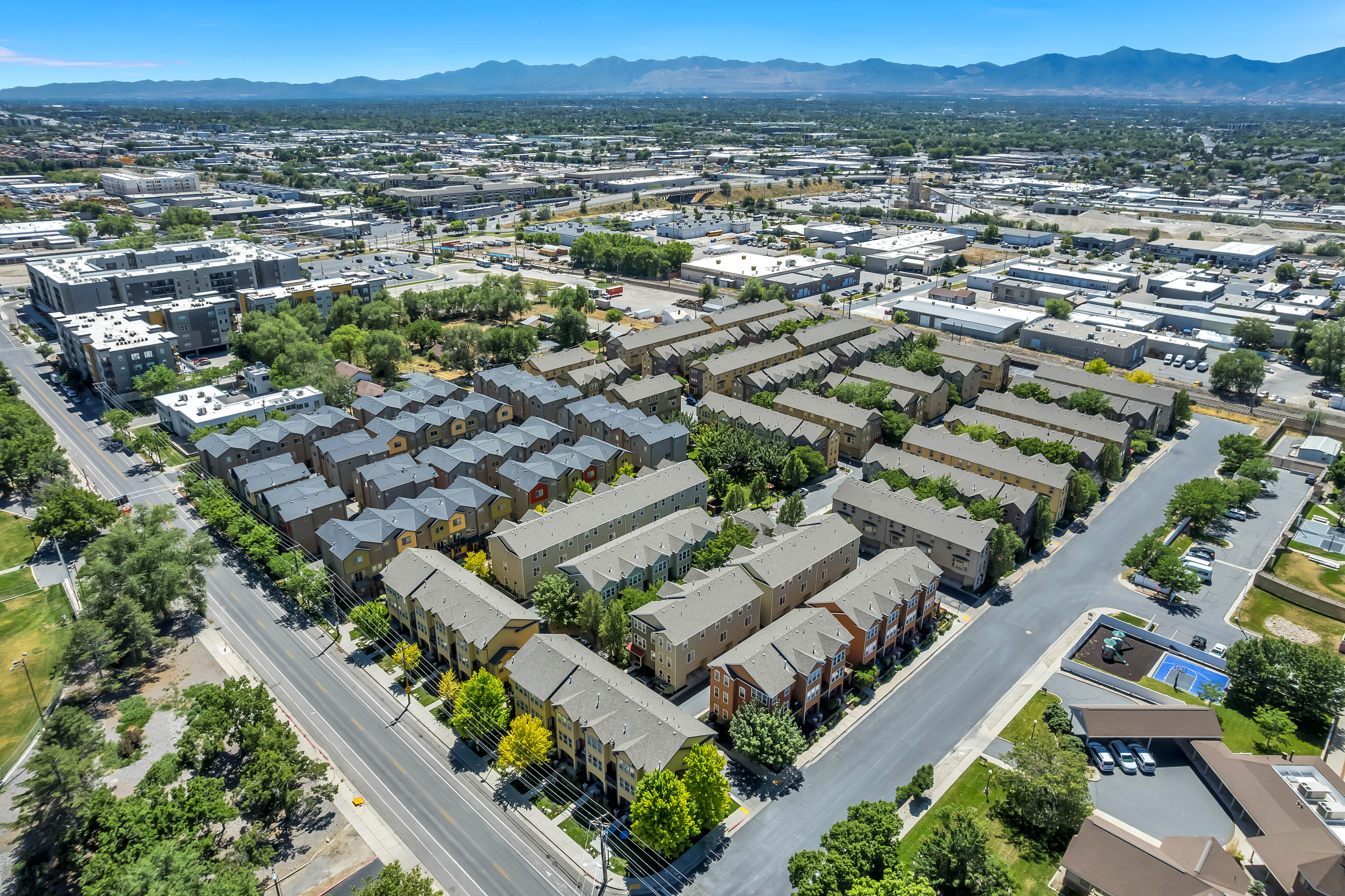Aerial perspective showcasing a residential development with multiple rows of townhomes and apartment complexes