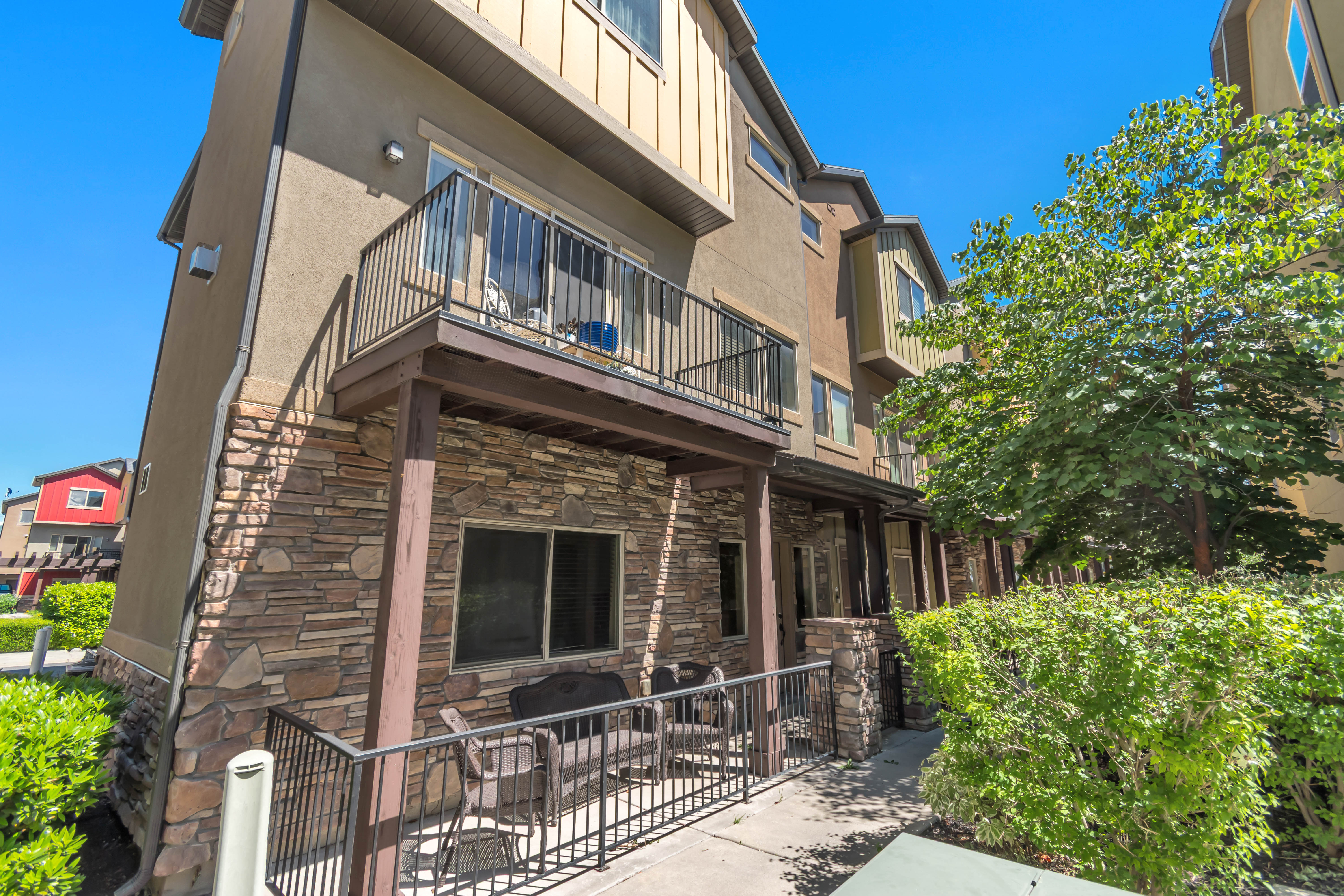 Multi-story townhome exterior featuring stone veneer and stucco siding