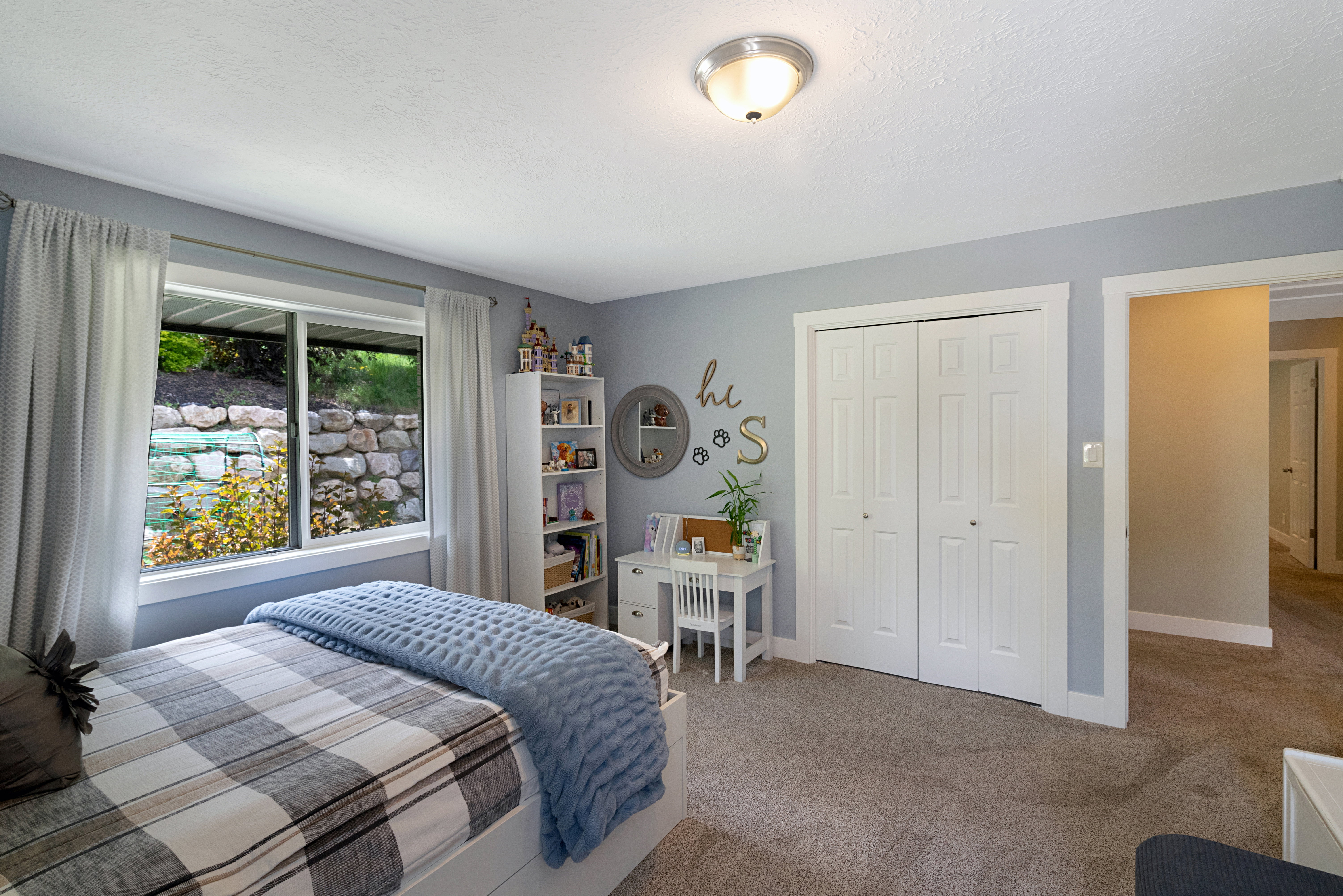 Bedroom featuring light gray wall paint, neutral carpet, a double-door bi-fold closet, and a ceiling-mounted light fixture