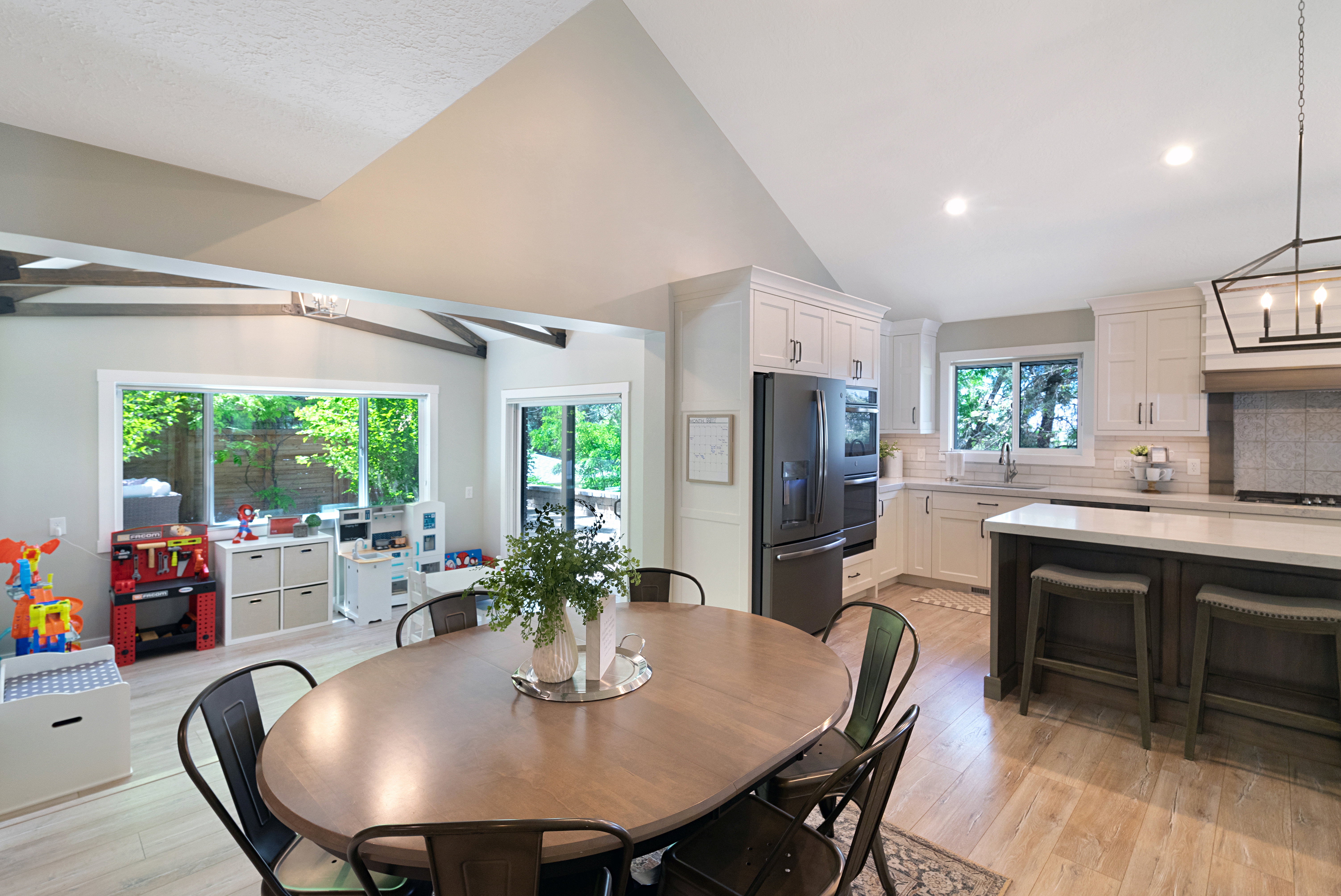 Open concept living area featuring wood-finish flooring and vaulted ceilings with exposed beams