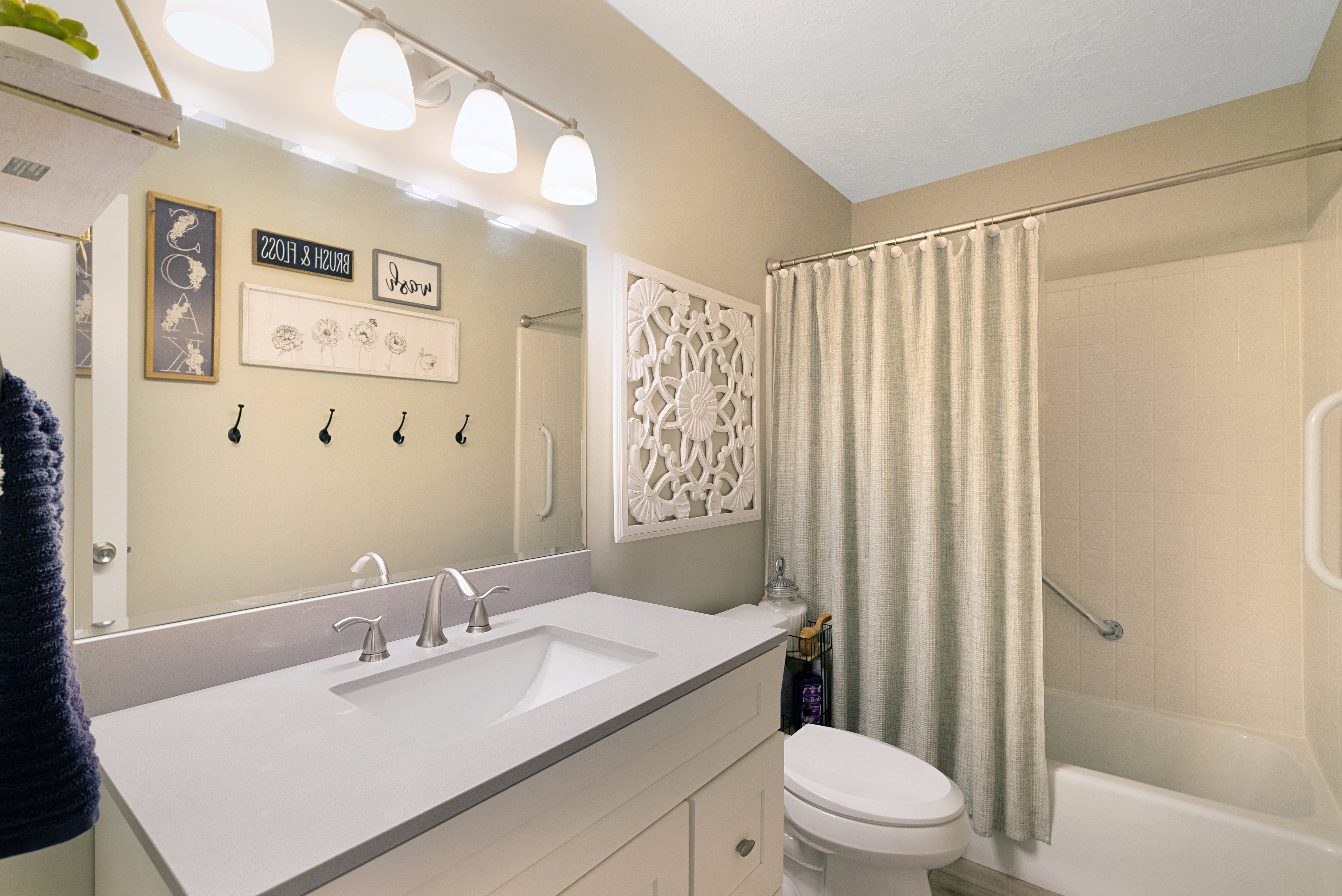 Bathroom featuring a built-in vanity with an undermount sink, brushed nickel faucet, and a light-toned countertop