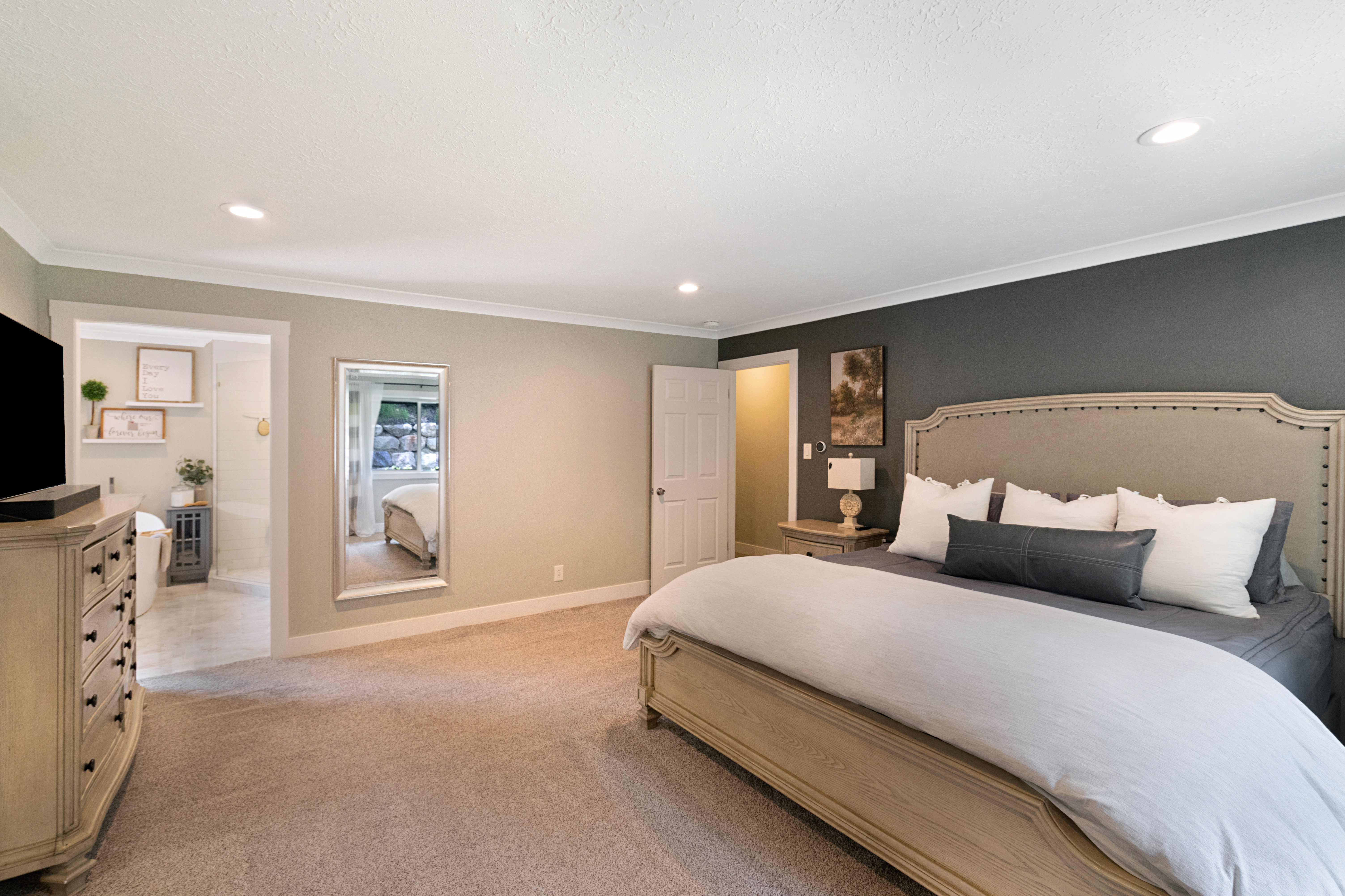 Spacious bedroom featuring recessed lighting, crown molding, light-toned carpeting, and a contrasting accent wall