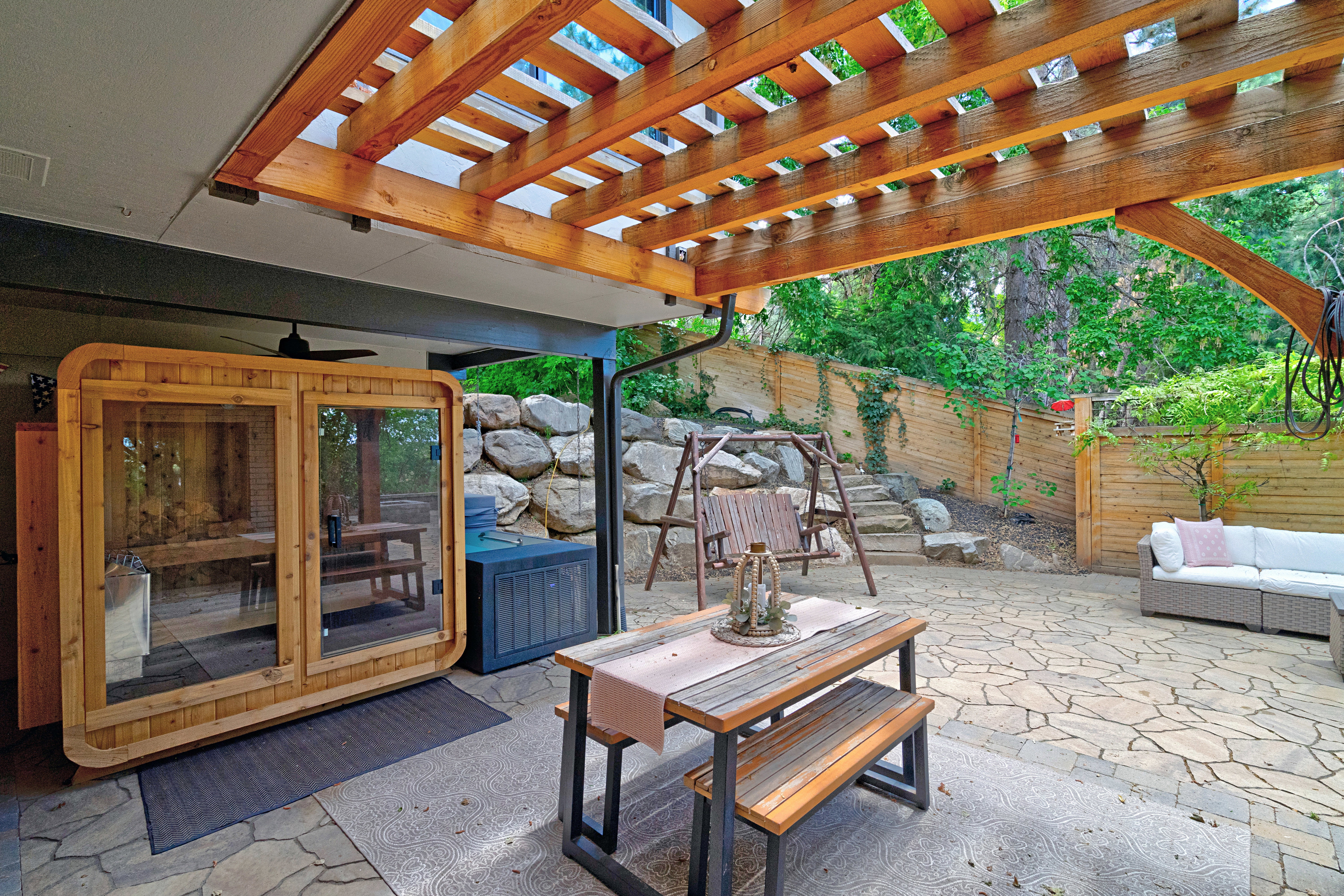 Expansive outdoor patio featuring a stone paver surface and a wooden pergola