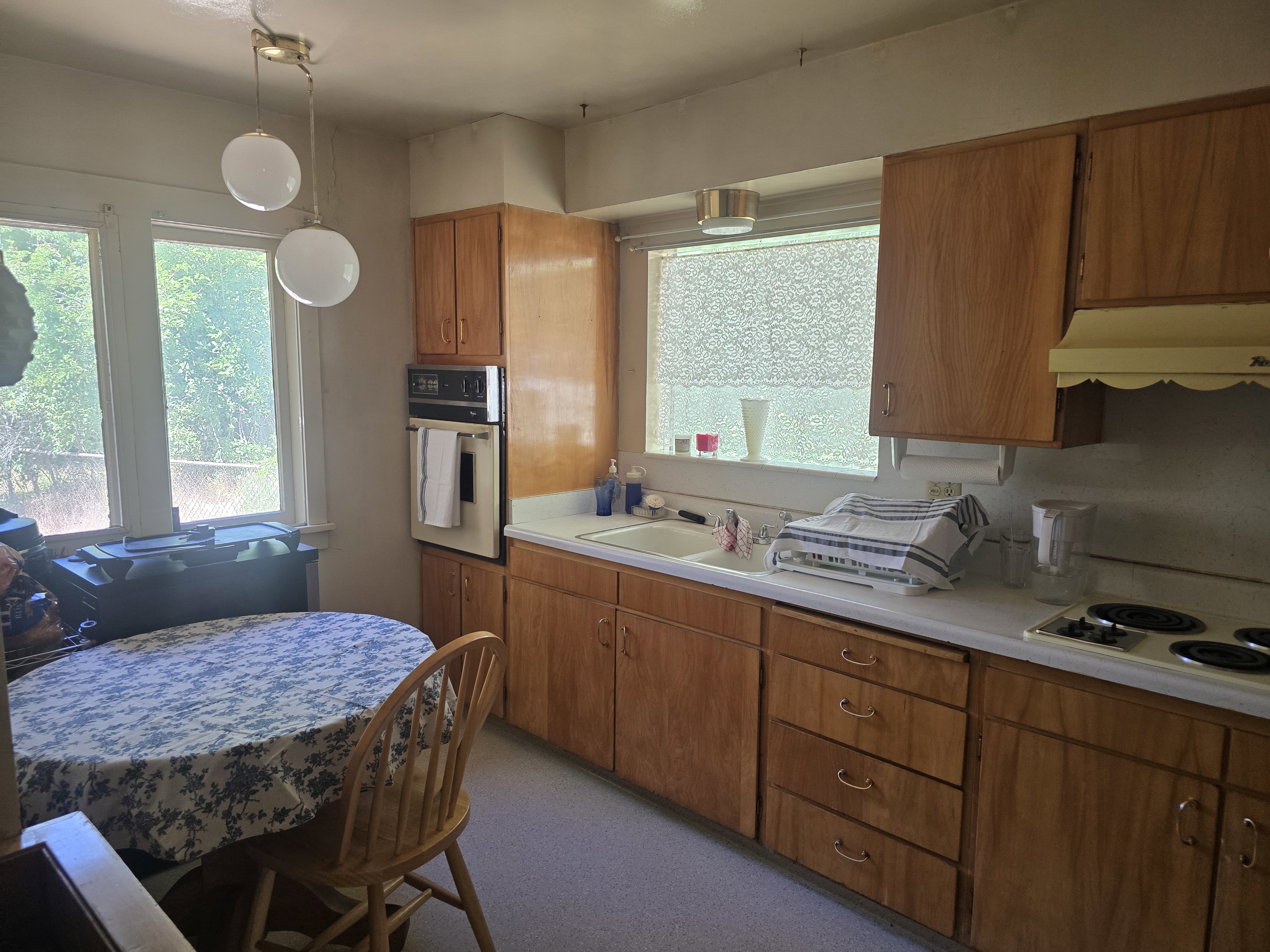 Kitchen featuring warm wood cabinetry, white countertops, and dual basin sink
